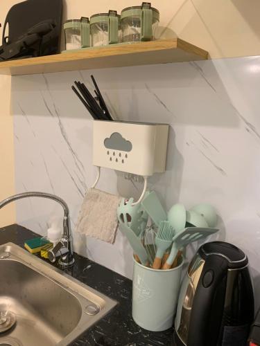 a kitchen counter with a sink and a cup of utensils at Mino Homestay in Hanoi