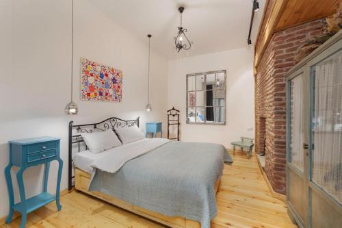 une chambre avec un lit et un mur de briques dans l'établissement Duplex Opera 3, à Tbilissi