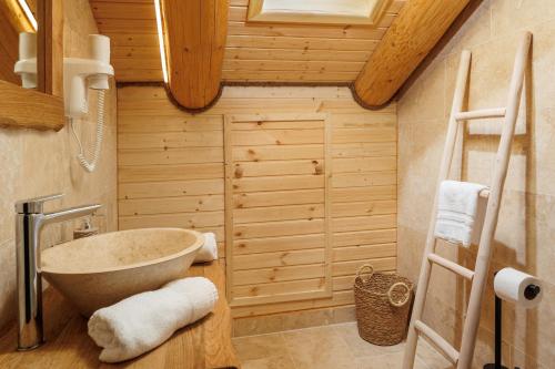 Chalet Rozmarin Predeal في بريدال: حمام مع حوض وحوض استحمام في الغرفة
