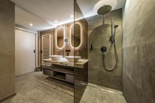 a bathroom with two sinks and two mirrors at Hotel Gasthof Brücke in Mayrhofen
