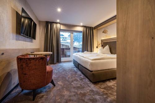 a hotel room with a bed and a chair at Hotel Gasthof Brücke in Mayrhofen