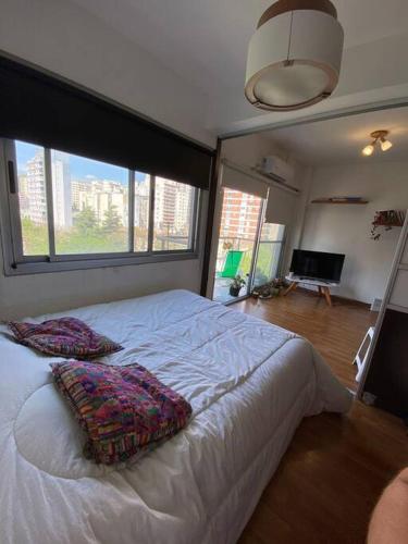 um quarto com uma cama grande com duas almofadas em Deleuxe Studio en Caballito em Buenos Aires