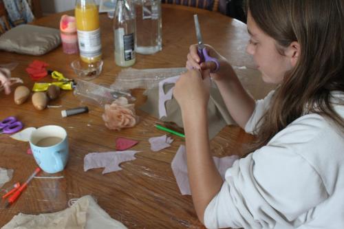 a young woman cutting paper on a table at Malin Head SolasTobann ArtHouse Room 1 En-suite in Malin Head
