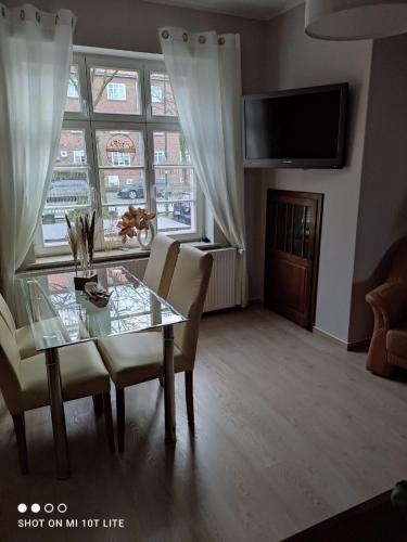 ein Esszimmer mit einem Tisch, Stühlen und einem Fenster in der Unterkunft Ferienwohnung Henny in Wismar