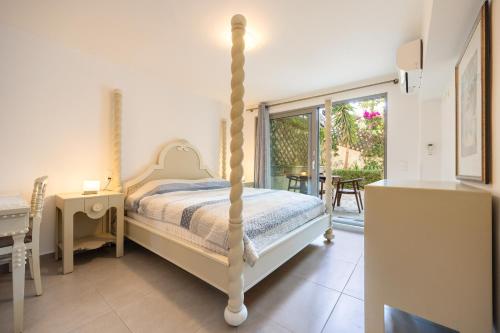 a bedroom with a four poster bed and a balcony at Beachside Bungalows in Athens