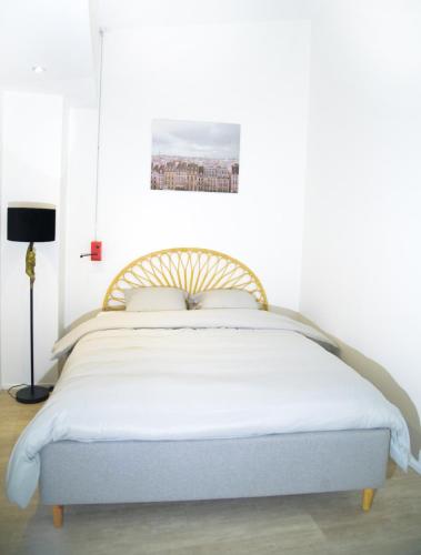 une chambre avec un lit avec un couvre-lit blanc dans l'établissement Appartment Montorgueil/Châtelet, à Paris