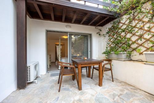 a patio with a wooden table and chairs at Beachside Bungalows in Athens