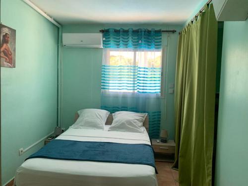 Bett in einem Zimmer mit einem Fenster und einem Bett sidx sidx sidx sidx in der Unterkunft Appartement Hibiscus in Basse-Terre