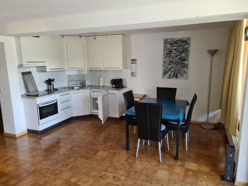 a kitchen and dining room with a table and chairs at Luegisland 1 Bühlmann in Arosa