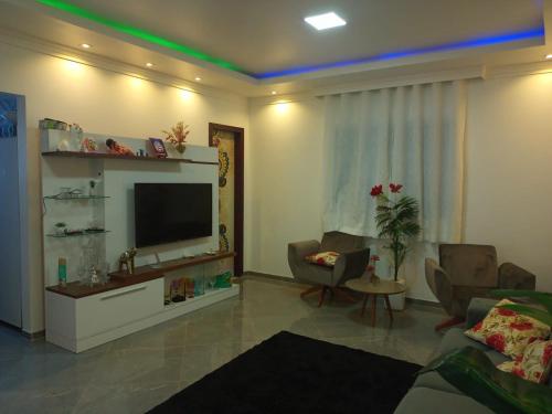 Casa em Condomínio, Piscina Privativa e Área Gourmet في كامساري: غرفة معيشة مع تلفزيون بشاشة مسطحة وأريكة