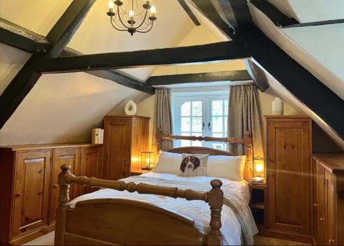 a bedroom with a large bed with wooden furniture at China Cottage - Quaint, Cosy, Cotswolds Retreat in Charlbury
