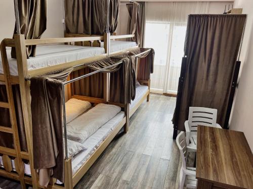 Cette chambre comprend plusieurs lits superposés et une table. dans l'établissement Hostel Gudauri Adventure, à Goudaouri