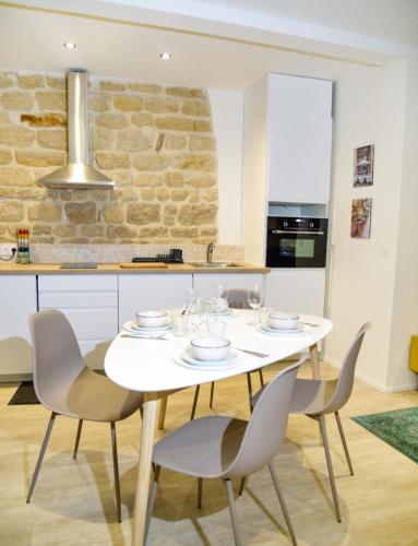 - une cuisine avec une table et des chaises blanches dans l'établissement Appartment Montorgueil/Châtelet, à Paris