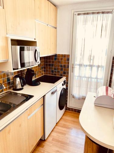 a kitchen with a sink and a microwave at 2 room apartment in the center close to the slopes in Valberg