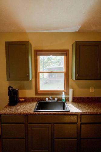 a kitchen with a sink and a window at Maple Creek Cabin, minutes from Cook Forest, ANF in Marienville