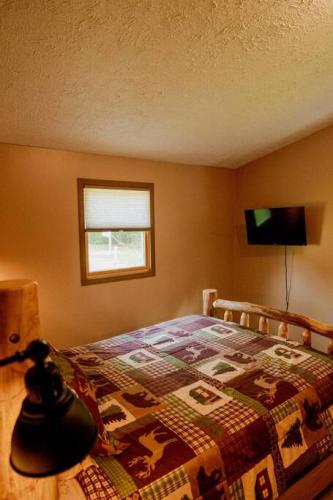 a bedroom with a bed with a quilt on it at Maple Creek Cabin, minutes from Cook Forest, ANF in Marienville