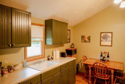 une cuisine avec un évier et une table à l'intérieur dans l'établissement Cozy Cottage near Cook Forest Park, ANF, à Marienville