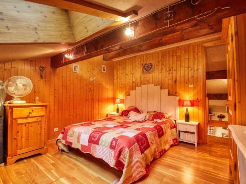 une chambre avec un lit dans une pièce aux murs en bois dans l'établissement Charmant duplex à Morillon, proche télécabine et lac bleu, idéal vacances montagne - FR-1-642-54, à Morillon