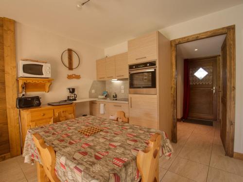 Il comprend une cuisine avec une table et une cuisine avec une table. dans l'établissement Bel appartement T3 avec terrasse, 2 chambres à Morillon - FR-1-642-25, à Morillon