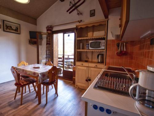 une cuisine avec une table et des chaises et une table et une cuisine dans l'établissement Charmant duplex mezzanine à Morillon près télécabine - FR-1-642-38, à Morillon