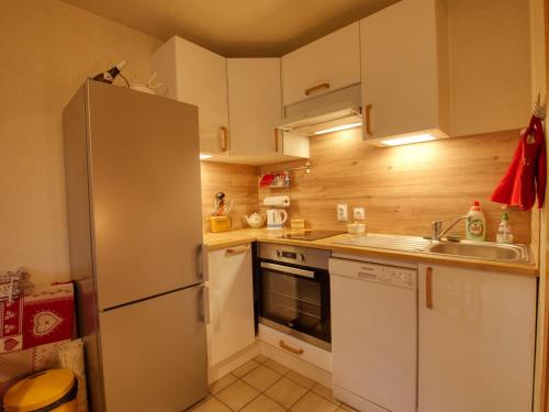 La cuisine est équipée d'un réfrigérateur et d'un évier. dans l'établissement Appartement rénové 4-6 pers, proche village, télécabine – Morillon - FR-1-642-59, à Morillon