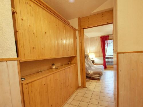 un couloir avec des armoires en bois et une chambre avec un lit dans l'établissement Appartement rénové 4-6 pers, proche village, télécabine – Morillon - FR-1-642-59, à Morillon