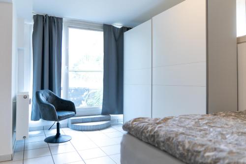 1 dormitorio con silla frente a una ventana en FeWo Bensing, en Forchheim