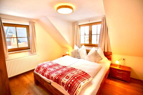 a bedroom with a bed and two windows at Chalet Mama in Pruggern