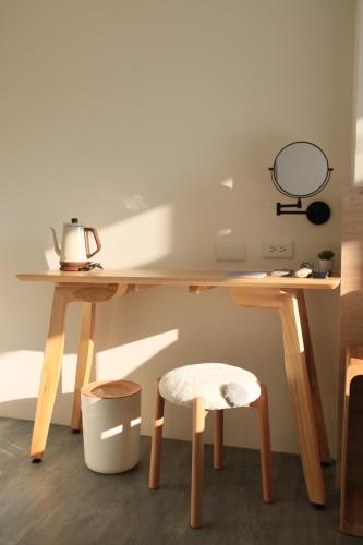 a wooden desk with a mirror and a stool at 161 Easy Inn in Yuchi