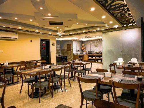- un restaurant avec des tables et des chaises dans une salle dans l'établissement TAJ Hotel, à Aqaba