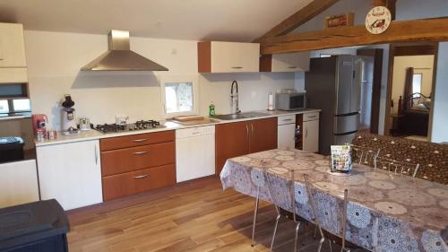 une cuisine avec une table au milieu dans l'établissement La Thibaudière Gite 70m2, à Mirebeau