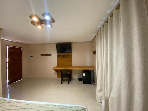 ein Wohnzimmer mit einem Tisch und einem Vorhang in der Unterkunft Pousada Baluarte in Tutóia