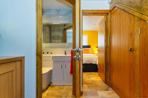 a kitchen with a sink and a bed in a room at BISHOPS TAWTON SNOWDROP COTTAGE 3 Bedrooms in Bishops Tawton