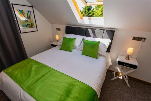 a bedroom with a large bed with green pillows at BISHOPS TAWTON SNOWDROP COTTAGE 3 Bedrooms in Bishops Tawton