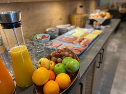 a bowl of fruit sitting on a counter with juice at Vico's Hotel & Restaurant Asperg in Asperg