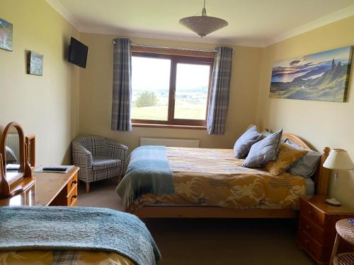 a bedroom with two beds and a window at House on the Falls in Portree