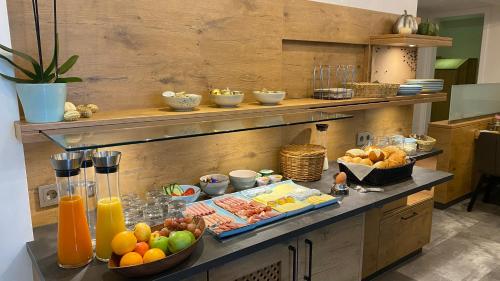 a breakfast buffet with fruit and drinks on a counter at Vico's Hotel & Restaurant Asperg in Asperg