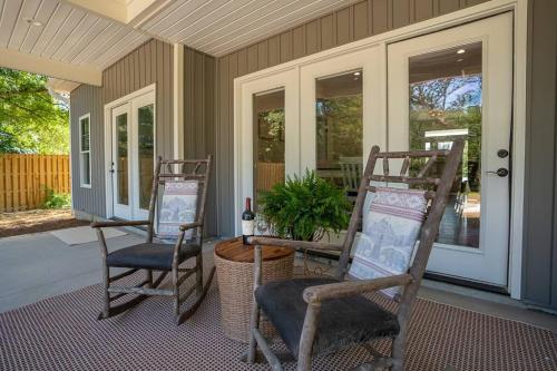 a porch with two chairs and a table with a plant at Relax, Rewind, Repeat - New Country Cottage in High Point