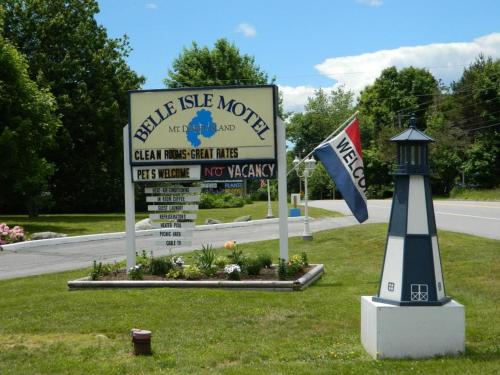 a sign and a lighthouse next to a street sign at Belle Isle Motel in Bar Harbor