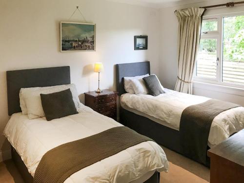 a bedroom with two beds and a window at Glen Mhor in Glenelg