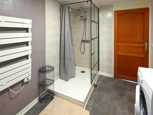 a shower with a glass door in a bathroom at LE CONCORDE-WIFI-Clim-Parking-3étoiles-OcKeys in Bram