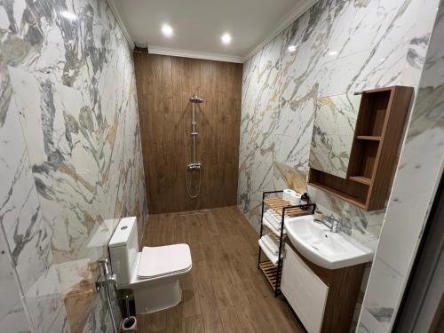 a bathroom with a toilet and a sink and a shower at Elegant and cozy room ARAKS in Kostinbrod