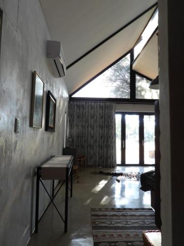 a living room with a table and a large window at Ibenstein Safaris in Dordabis