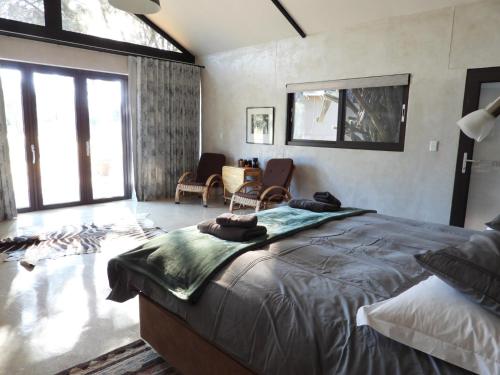 a bedroom with a large bed and a living room at Ibenstein Safaris in Dordabis