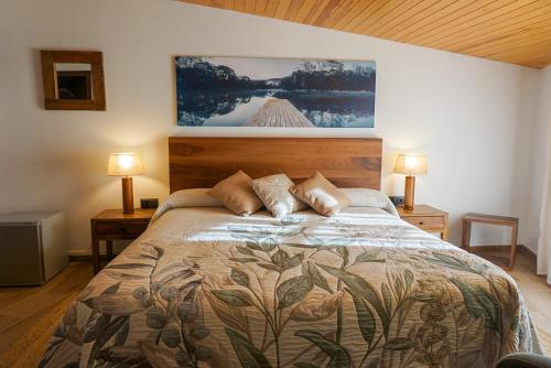 a bedroom with a bed with two lamps on it at La Sala de Camós in Camós