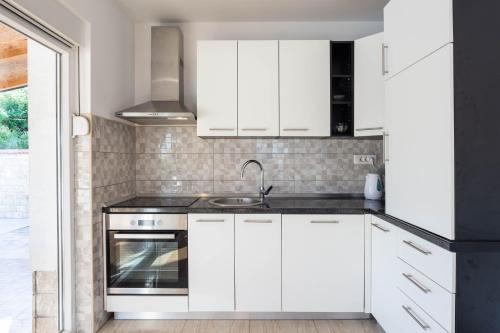 a kitchen with white cabinets and a sink at Vacation villa Matic with 7 bedrooms in Sinj