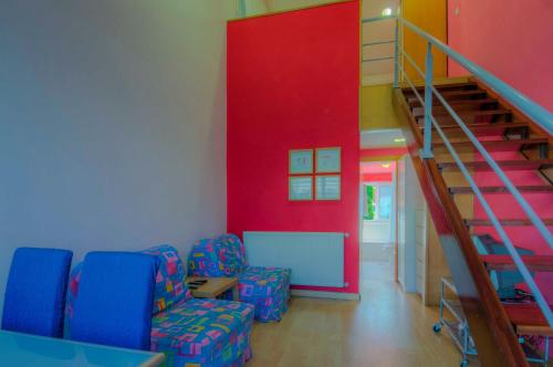 Zimmer mit 2 Stühlen und einer Treppe in der Unterkunft Apartamentos Turísticos Silvano Posada de Llanes in Posada de Llanes