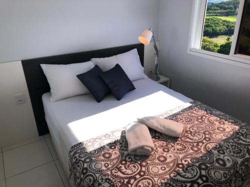 um quarto com uma cama grande com duas toalhas em APTO Vista INCRIVEL do VALE DOS VINHEDOS com AR e Garagem Coberta em Bento Gonçalves
