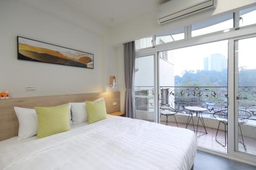 a bedroom with a white bed and a balcony at 161 Easy Inn in Yuchi