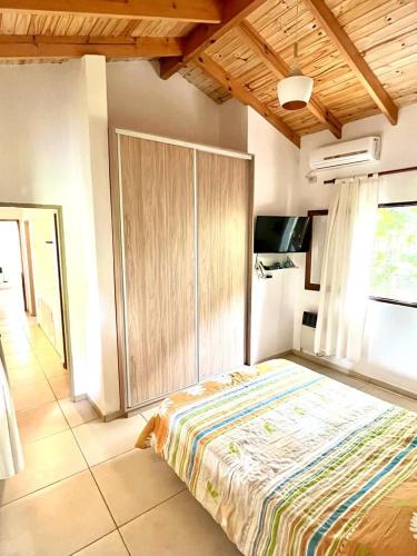 a bedroom with a large bed and a wooden cabinet at La Casita de Karen in Villa General Belgrano